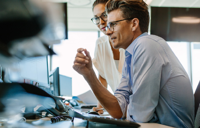 Photograph of two sales engineering professionals looking at a computer screen